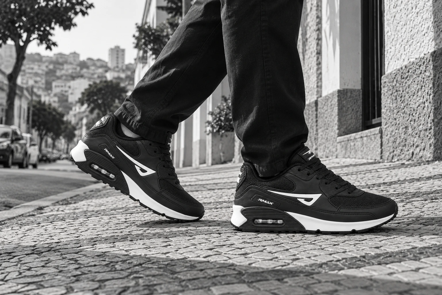 Cena urbana em preto e branco, com uma pessoa caminhando de Air RMax 90 pela calçada