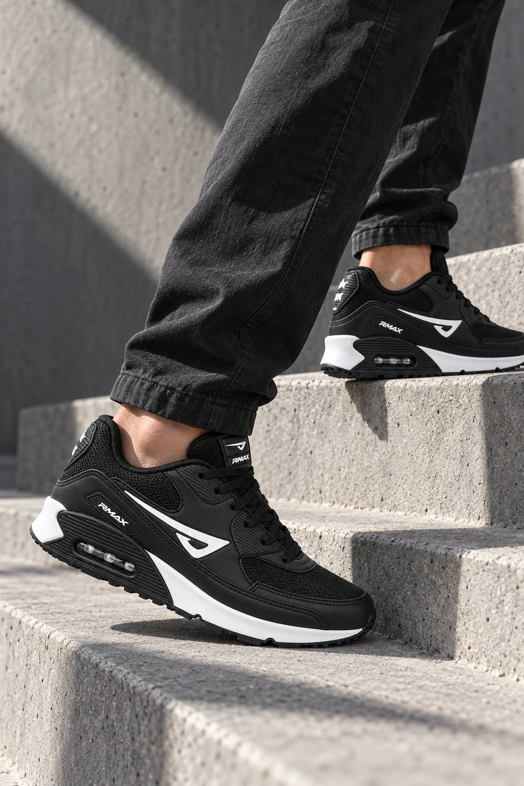 Air RMax 90 preto e branco em uso, subindo degraus de concreto na cidade
